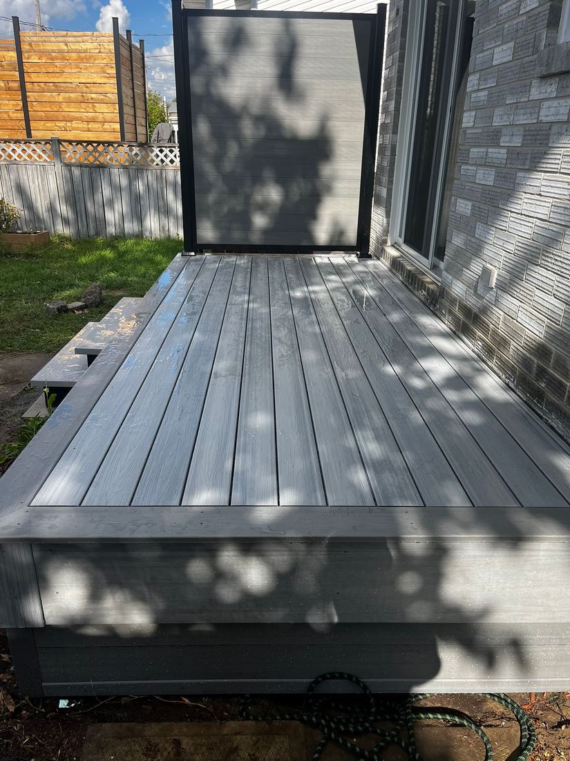 Detail of the grey composite decking and black privacy screen, seen from above