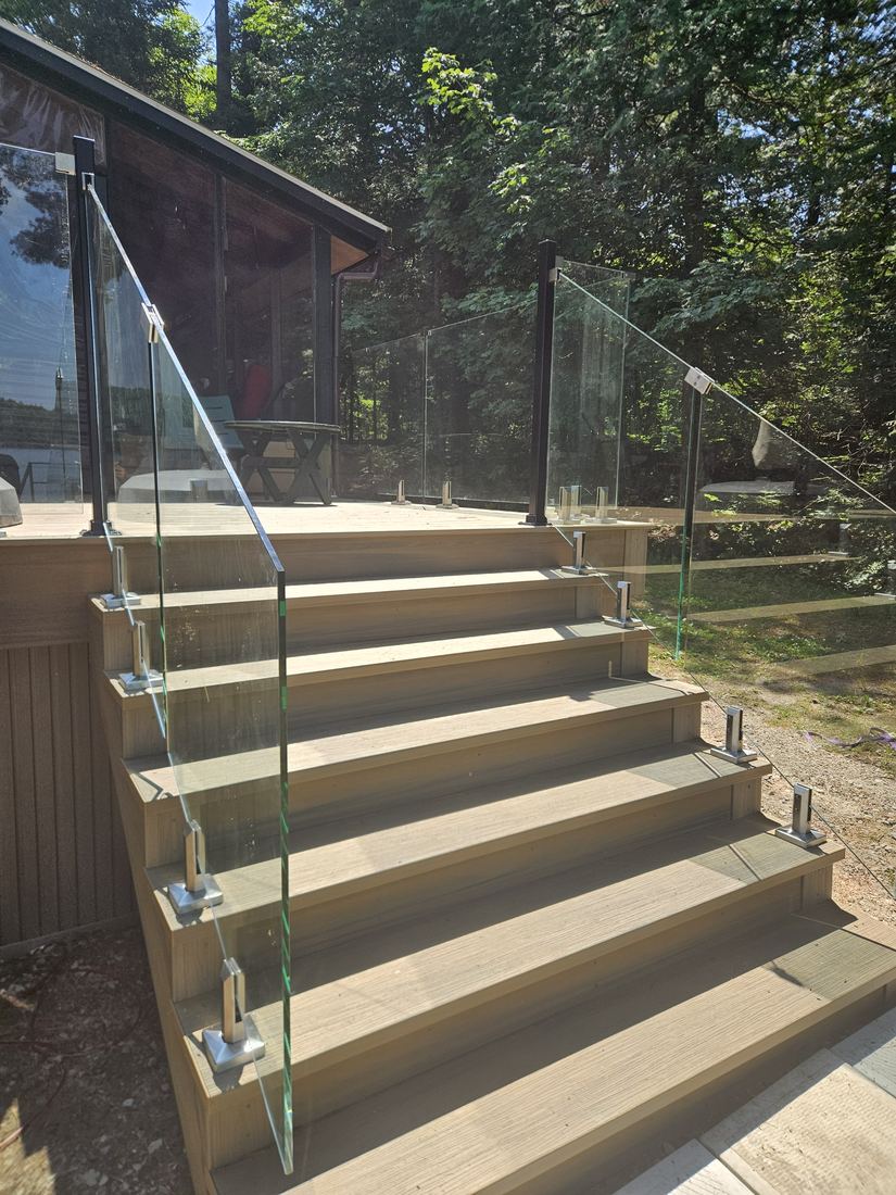 Detail of composite steps and glass panels on stainless clamps, chalet in the background