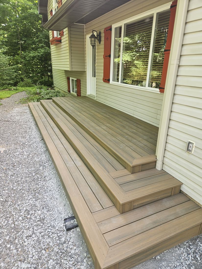 Brown composite entry steps and landing at a front door, with mitred border boards