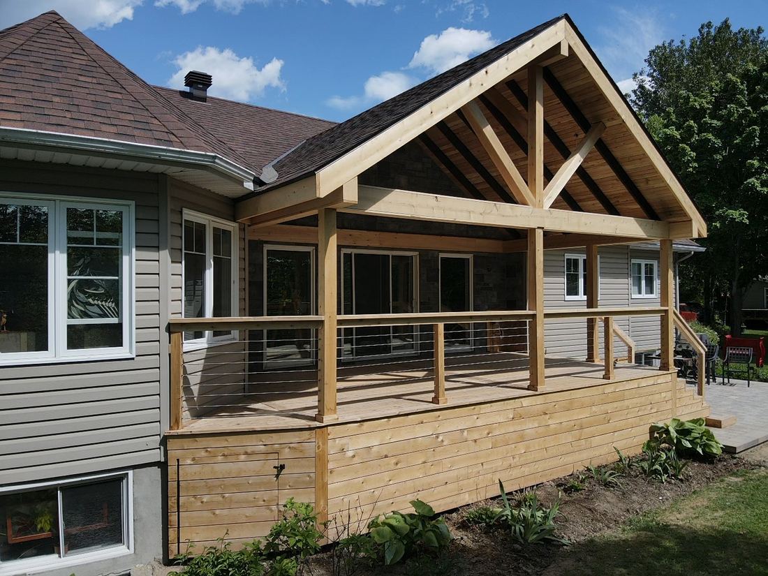 Cedar deck with exposed-beam gable roof and steel cable railing