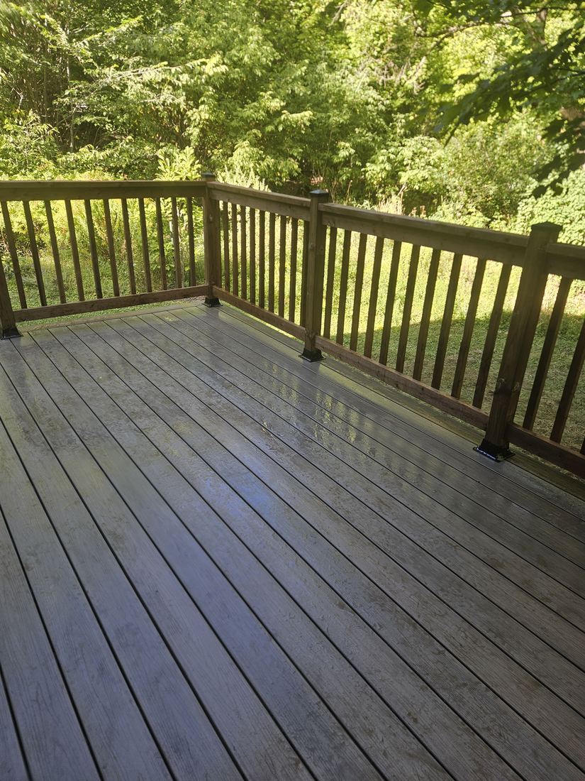Grey-brown composite deck with pressure-treated wood railing and vertical balusters