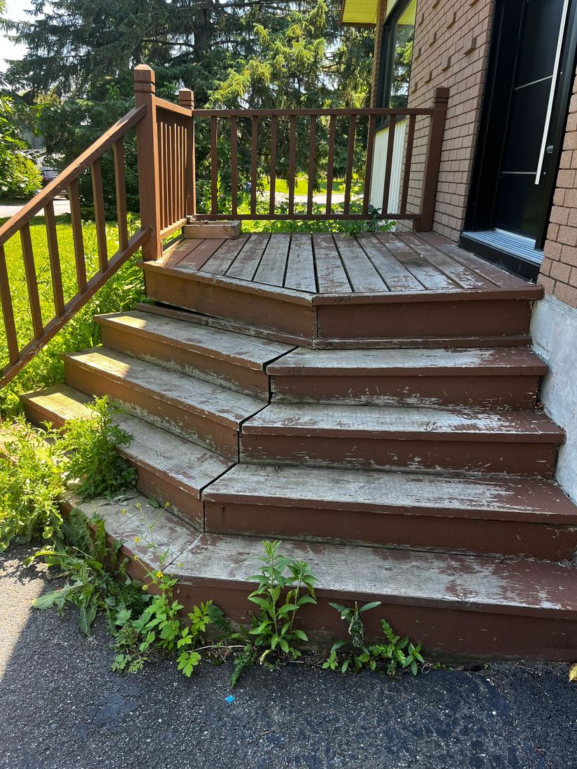 Old entry porch in peeling painted wood, with corner steps and wood railing, before renovation