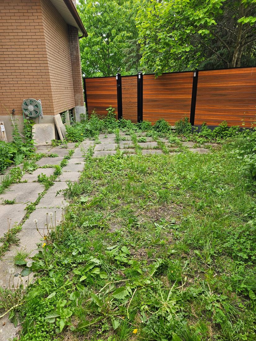 Privacy fence with horizontal wood-look composite slats and black posts, yard before landscaping